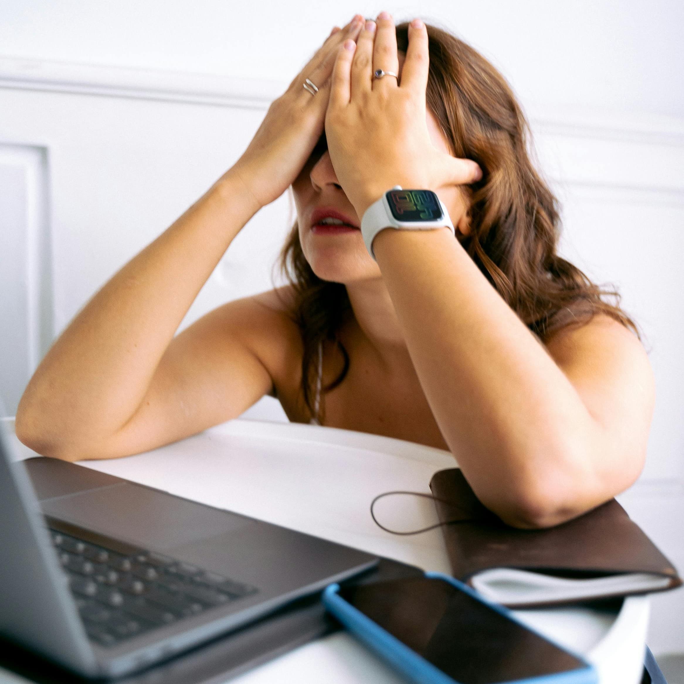 Pessoa frustrada tentando trabalhar e responder mensagens ao mesmo tempo